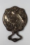 An Art Nouveau style hand mirror with embossed decoration of a maiden, with flowing hair, flowers