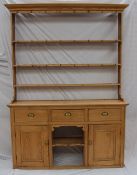 A Victorian pine kitchen dresser, the moulded cornice above three open shelves, the base with a