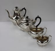 An Edward VII George V silver four piece tea set, of oval form with stop fluted body, comprising