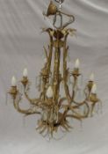 A modern cream painted nine branch chandelier with leaf and lustre drop decoration, together with
