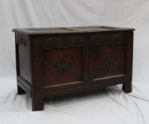 An 18th century oak coffer, the two panelled top above a carved two  panel front on stiles, 101cm
