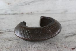 A bronze bangle with line and circle decoration, approximately 1328 grams