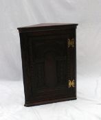 A 19th century oak hanging corner cupboard carved with flower heads and leaves, 51cm wide x 69cm