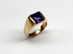 An 18ct yellow gold gentleman`s dress ring set with a blue stone, possibly tanzanite