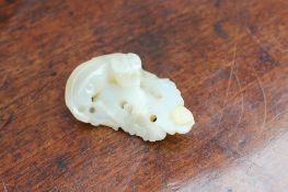 A Chinese jade carving of a dog on a pierced rocking base, 6cm long