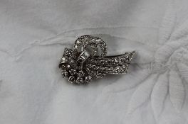 A diamond clip brooch, set with brilliant and baguette cut diamonds to a white metal setting in a