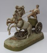 A Royal Dux figure group modelled as a classical chariot driven by a standing male wearing a drape,