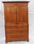 A 19th century oak linen press, the moulded cornice above a pair of four panelled doors with a