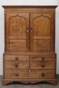 An early 19th century oak linen press, the moulded cornice above a pair of panelled doors, the base