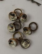 A set of six intaglio reverse painted rock crystal shirt studs depicting the head of a terrier