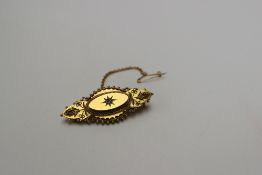 A Victorian yellow metal bar brooch of pointed oval shape with a central diamond marked 15ct,
