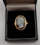 A shell cameo ring depicting a classical male portrait in profile in a yellow metal rubbed over