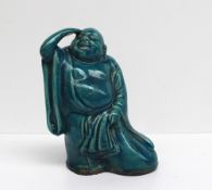 A Chinese turquoise glazed buddhistic figure holding a sack, 23cm high, together with a pair of
