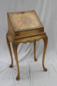 A ladies writing bureau applied with a cream paint effect and painted with roses and garden