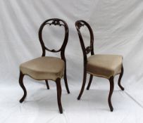 A pair of Victorian balloon back dining chairs with carved back above a pad seat on shaped legs (2)