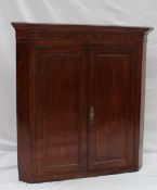 An 18th century oak standing corner cupboard top with a moulded cornice and a pair of cupboard