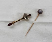A moon stone and enamel decorated stick pin, together with a cabochon hard stone set stick pin