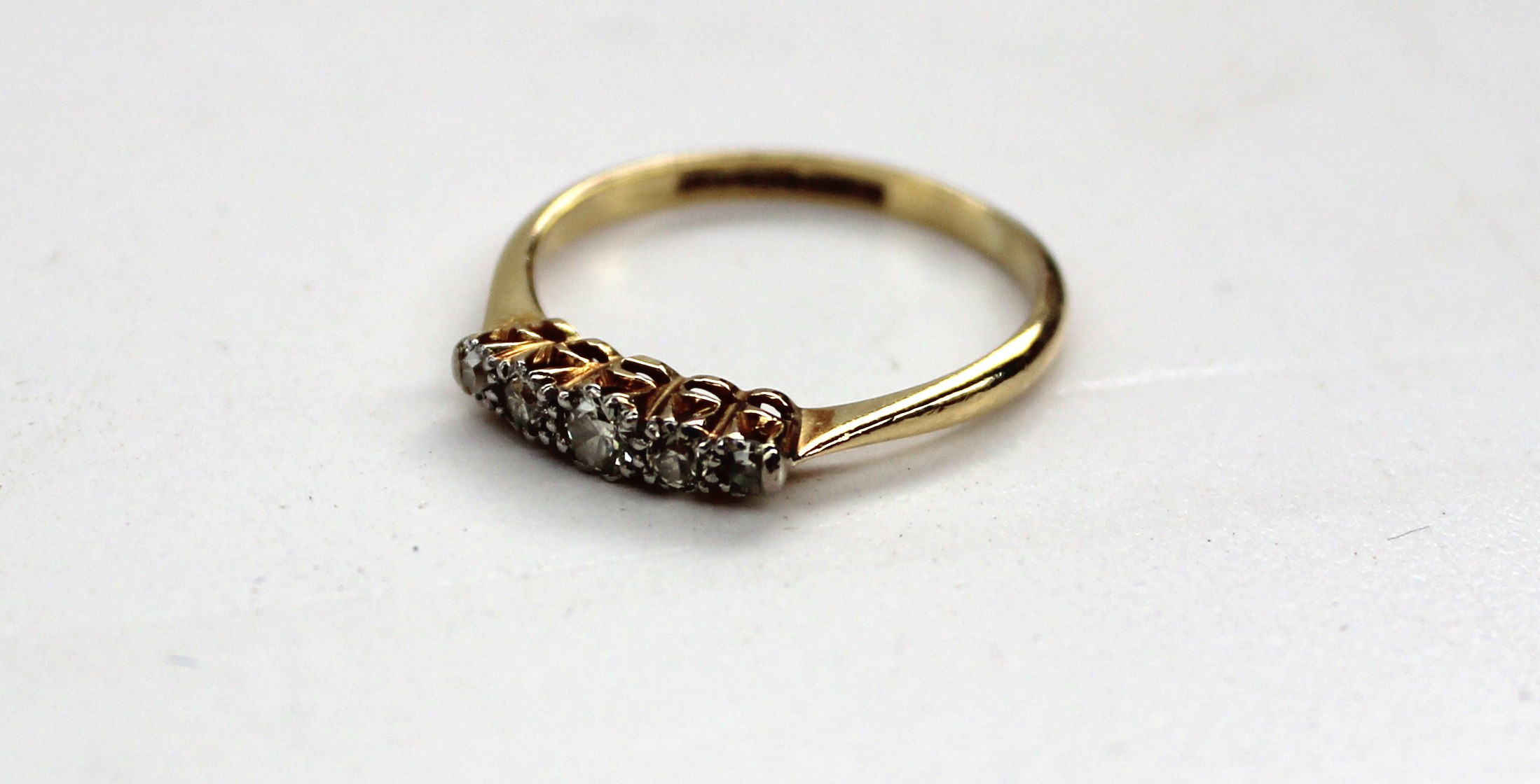 A five stone diamond ring with graduated old cut diamonds to a platinum setting and 18ct gold shank