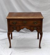 An 18th century oak low boy, the moulded rectangular planked top above a single drawer and two faux