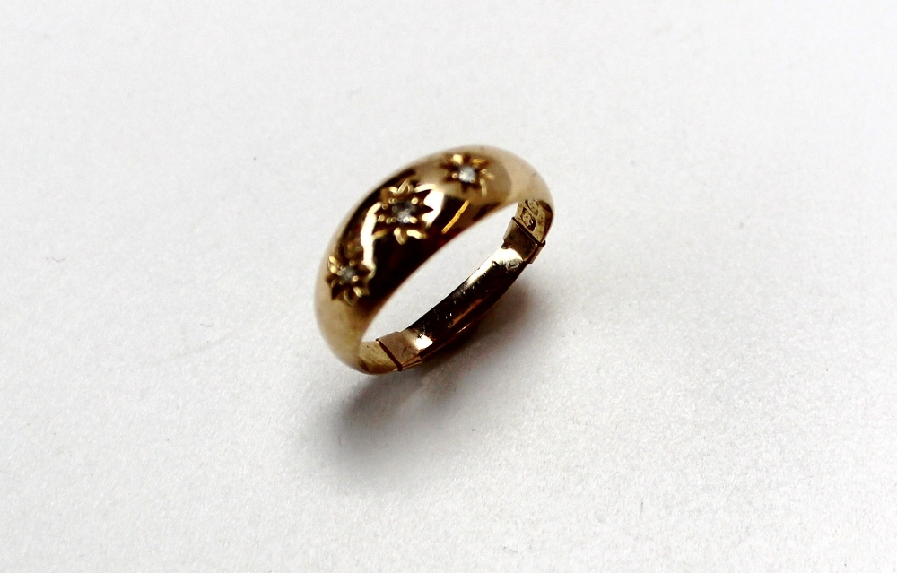 A three stone diamond gypsy ring set to an 18ct gold shank