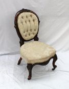 A Victorian walnut spoon back nursing chair, with button back upholstery and pad seat on carved