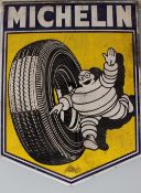 An enamelled tin sign advertising "Michelin" of shield shape depicting the Michelin Man running