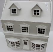 A dolls house of Georgian style with dormer windows, painted white