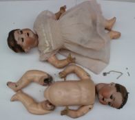 A pair of Armand Marseille bisque head dolls with closing eyes, open mouth and teeth, moulded to the