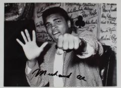 A black and white photograph of Muhammad Ali signed in black marker pen