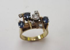 A sapphire and diamond ring set with three oval sapphires and five brilliant cut diamonds to a