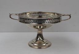 A George V silver twin handled pedestal bowl, with a pierced rim, on a spreading foot, Sheffield,
