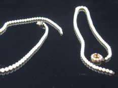 A pearl necklace, with graduated pearls and a yellow metal pendant