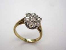 A diamond cluster ring set with seven brilliant cut diamonds to a white metal claw setting and an