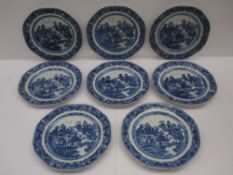 A set of eight Chinese porcelain blue and white plates decorated in a variation of the willow