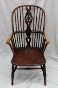 A 19th century Windsor Chair, the hooped stick back with a central wheel back splat, above a solid