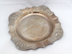 An Indian white metal dish of square form embossed with figures and animals, engraved to the
