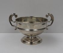A George V silver twin handled pedestal bowl, with a ribbed bowl on a spreading foot, Birmingham,
