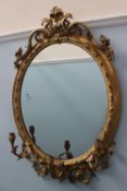 An 19th century gilt gesso girandole mirror, the cresting rail decorated with scrolls and fruit