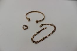 A 9ct yellow gold slave bangle together with a 9ct yellow gold bracelet, and an earring,