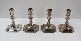 A set of four Elizabeth II Britannia standard silver candlesticks with knopped stems on square