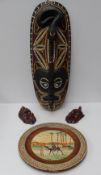 An oval treen mask, possibly Maori, carved with a snake and an eagle, with shell eyes, 70cm long,