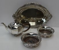 An electroplated oval dish together with a pair of bottle coasters and a teapot.