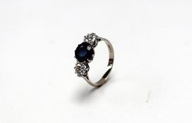 A sapphire and diamond line ring set with a central sapphire flanked by two brilliant cut diamonds