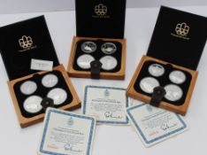 Three sets of 1976 Canadian silver commemorative Olympic coins, in original cases and boxes