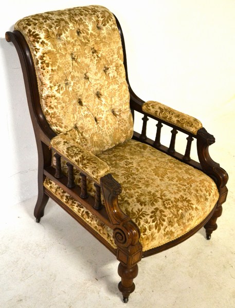 AN EDWARDIAN MAHOGANY AND UPHOLSTERED ARMCHAIR the deep-buttoned back supported by channelled