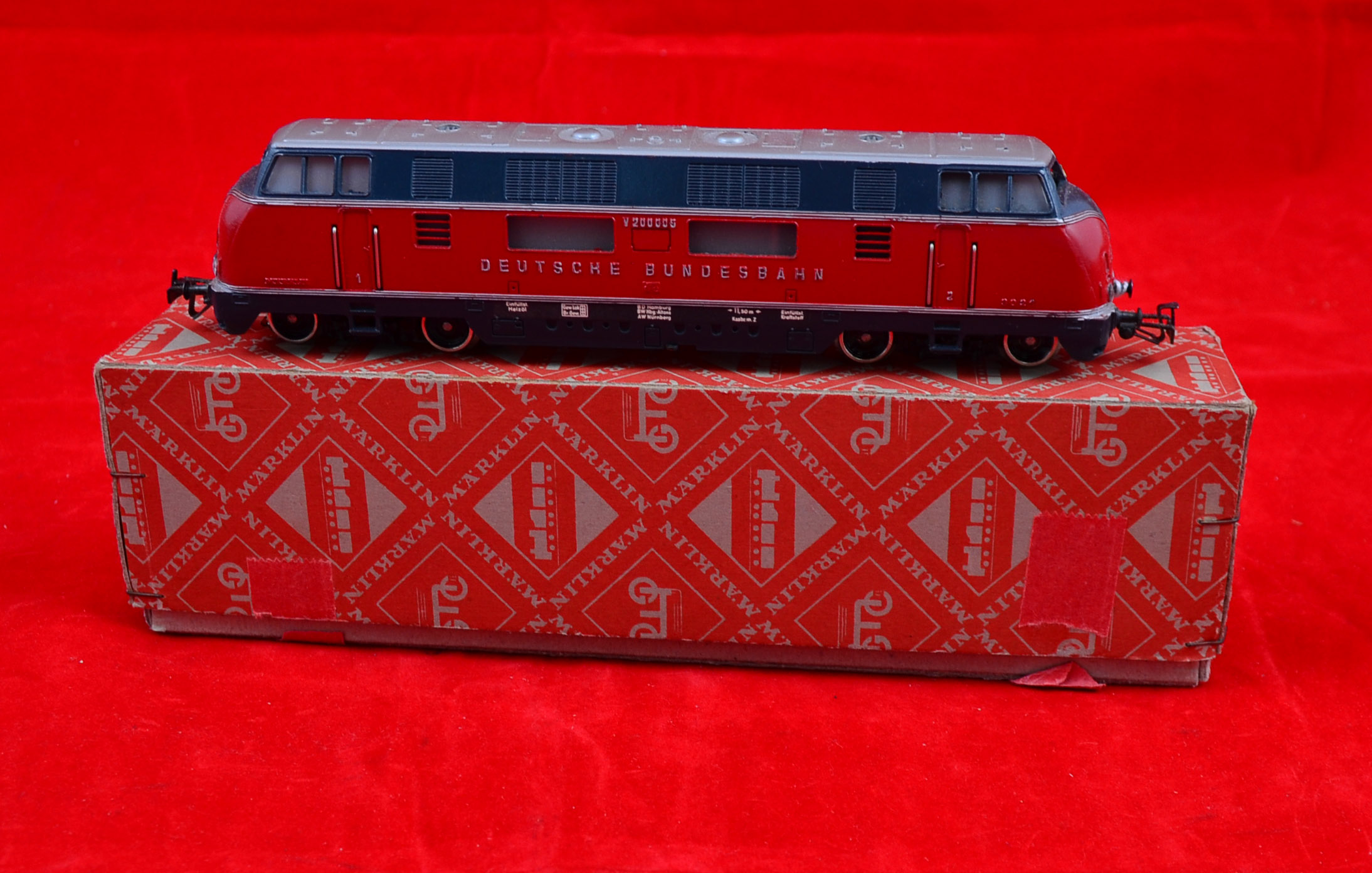 HO gauge, Marklin 3021 3-rail DB maroon/grey V200 Bo-Bo livery `200006`. VG/E in VG red diamond