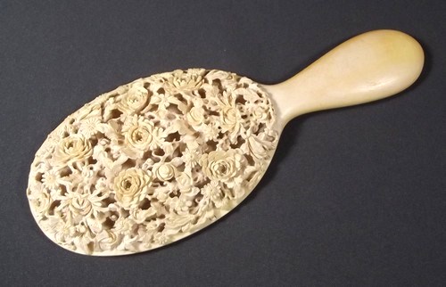 IVORY HAND MIRROR
A 19th century ivory hand mirror, the back carved in deep relief with flowers