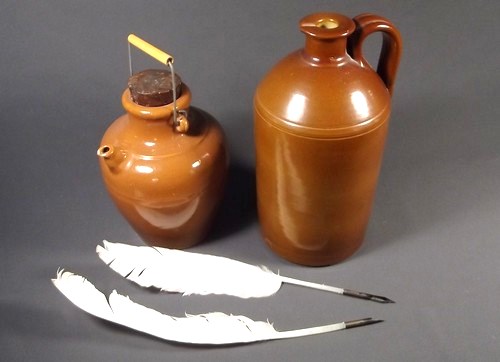 STONEWARE BOTTLES ETC.
A brown glazed stoneware ink bottle, two quill pens and a stoneware stoppered