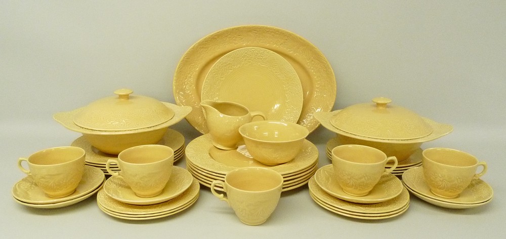 A Clarice Cliff pottery part dinner and tea service incised to the rim with flowers and leaves,