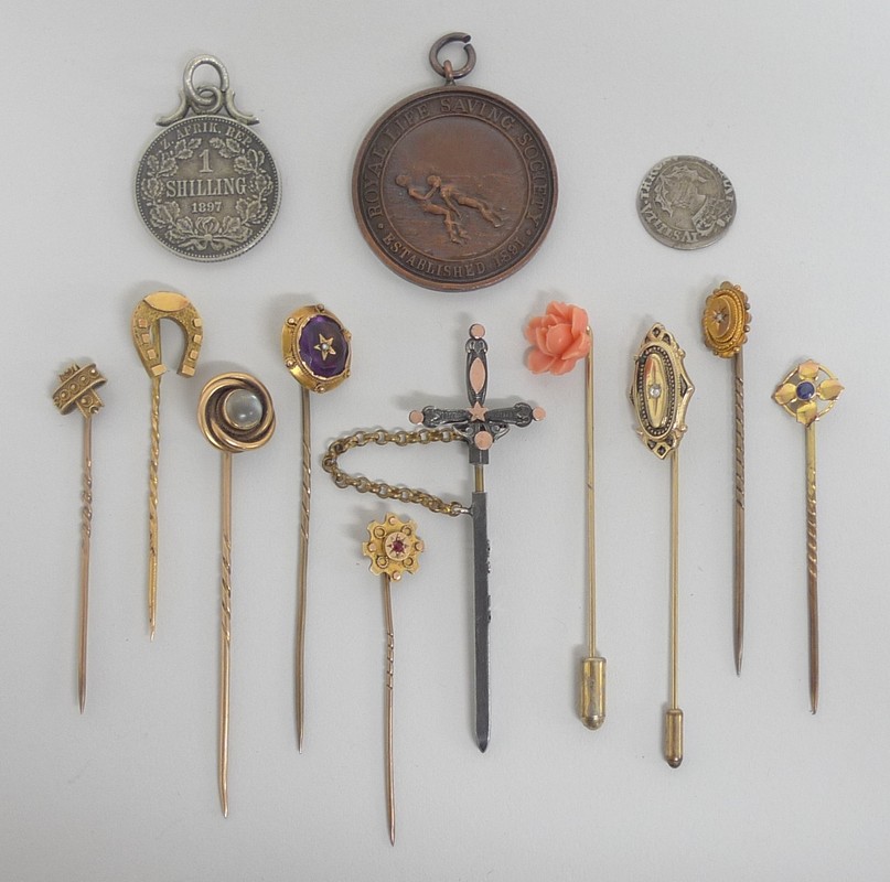 A quantity of gold and gilt stick pins, some gem set, silver `Rouen` sword pin, Royal Life Saving